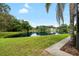 Beautiful backyard pond view framed by lush trees and manicured lawn at 6621 Appaloosa Dr, Tampa, FL 33625