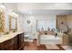 Full bathroom view highlighting double vanity, soaking tub with decorative tile, and glass enclosed shower at 6621 Appaloosa Dr, Tampa, FL 33625