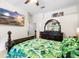Bedroom with dark wood furniture and a tropical leaf patterned bedspread at 6621 Appaloosa Dr, Tampa, FL 33625