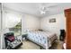 This is a cozy bedroom with a palm-print bedspread, a window, and a small work area at 6621 Appaloosa Dr, Tampa, FL 33625