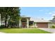 Charming single-story home with a well-maintained lawn, lush landscaping, and a two-car garage at 6621 Appaloosa Dr, Tampa, FL 33625