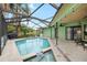 Screened in pool area with lounge chairs, ceiling fans, view of the pond and lush landscaping at 6621 Appaloosa Dr, Tampa, FL 33625