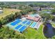 Aerial view of community recreation facilities, with tennis courts, bocce ball, pool, and clubhouse at 6630 Spring Flower Dr # 14, New Port Richey, FL 34653