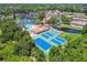 Aerial view of community: pool, clubhouse, tennis, bocce ball, lake, and lush landscape at 6630 Spring Flower Dr # 14, New Port Richey, FL 34653