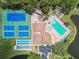 Aerial view of community amenities featuring two tennis courts, shuffleboard, pool, and clubhouse at 6630 Spring Flower Dr # 14, New Port Richey, FL 34653
