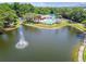 Aerial view of the community pool, tennis courts, and surrounding lush landscaping and water feature at 6630 Spring Flower Dr # 14, New Port Richey, FL 34653