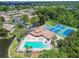 Aerial view of community amenities: swimming pool, tennis courts, bocce ball, and pond at 6630 Spring Flower Dr # 14, New Port Richey, FL 34653