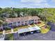 Aerial view of the condominium complex with trees, parking, and landscaping at 6630 Spring Flower Dr # 14, New Port Richey, FL 34653