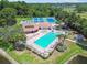 Aerial view of the community pool, clubhouse and tennis courts with beautiful landscaping at 6630 Spring Flower Dr # 14, New Port Richey, FL 34653