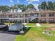 Condo complex featuring covered parking, bench seating, and lovely landscaping at 6630 Spring Flower Dr # 14, New Port Richey, FL 34653