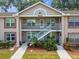 Charming two-story condo featuring a well-maintained lawn and exterior stairs at 6630 Spring Flower Dr # 14, New Port Richey, FL 34653