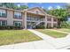 Condominium exterior with manicured lawn and stairs to the upper units at 6630 Spring Flower Dr # 14, New Port Richey, FL 34653