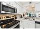 Bright kitchen boasts stainless steel appliances, stone backsplash, and white cabinetry at 6630 Spring Flower Dr # 14, New Port Richey, FL 34653