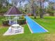 Community shuffleboard court with picnic gazebo and lush tropical landscape at 6630 Spring Flower Dr # 14, New Port Richey, FL 34653