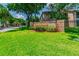 Community sign at Sunnybrook with lush landscaping and mature trees in the background at 6630 Spring Flower Dr # 14, New Port Richey, FL 34653