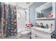 Charming bathroom featuring colorful shower curtains, white cabinets, and a white vanity at 6645 Freeport Dr, Spring Hill, FL 34608