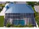 Aerial view showing the roofline, screened-in lanai, and swimming pool at 7114 Pelican Island Dr, Tampa, FL 33634