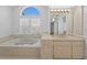 Comfortable bathroom with garden tub, bright vanity, and natural light from window at 7114 Pelican Island Dr, Tampa, FL 33634