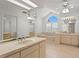 Bright bathroom with vaulted ceiling, soaking tub, double sinks, and large mirror at 7114 Pelican Island Dr, Tampa, FL 33634