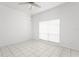 Bright bedroom featuring tile floors, a ceiling fan, and a large window at 7114 Pelican Island Dr, Tampa, FL 33634