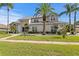 Beautiful two story home with a metal roof and palm trees in a well landscaped yard at 7114 Pelican Island Dr, Tampa, FL 33634