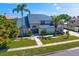 Beautiful front exterior with metal roof, lush landscaping and a cozy walkway to the front door at 7114 Pelican Island Dr, Tampa, FL 33634