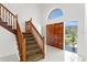 Bright foyer with grand wooden staircase, double doors, and large arched window offering ample natural light at 7114 Pelican Island Dr, Tampa, FL 33634