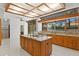 Gourmet kitchen boasts a coffered ceiling, granite countertops, an island cooktop, and ample natural light at 7114 Pelican Island Dr, Tampa, FL 33634