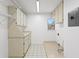 Efficient laundry room featuring built-in cabinets, countertop space, and tile flooring for easy maintenance at 7114 Pelican Island Dr, Tampa, FL 33634