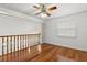 View of the bright loft area featuring hardwood floors, ceiling fan, and natural light at 7114 Pelican Island Dr, Tampa, FL 33634