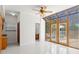 Bright sunroom with tile flooring, ceiling fan, and double doors leading to a private outdoor space at 7114 Pelican Island Dr, Tampa, FL 33634