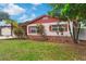 Charming home featuring a well-maintained lawn, landscaping, and brick accents at 7276 21St Street N, St Petersburg, FL 33702