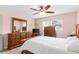Cozy main bedroom with light pink walls, ceiling fan and matching wooden furniture at 7276 21St Street N, St Petersburg, FL 33702