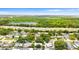 An aerial view shows a neighborhood near the highway, trees, and a lake at 7276 21St Street N, St Petersburg, FL 33702