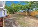 A spacious back yard enclosed with a wood fence, with a trimmed flower bed along the house at 7804 Bracken Dr, Port Richey, FL 34668