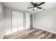Bedroom features wood-look flooring, ample closet space, and a ceiling fan at 7804 Bracken Dr, Port Richey, FL 34668