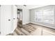 Light-filled bedroom with wood-look flooring, a large window, and neutral paint at 7804 Bracken Dr, Port Richey, FL 34668