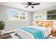 Bright bedroom with a light wood bed frame, ceiling fan, and large windows at 7804 Bracken Dr, Port Richey, FL 34668