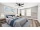 Cozy bedroom featuring a queen-size bed, ceiling fan, and two bright windows at 7804 Bracken Dr, Port Richey, FL 34668