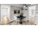 Bright dining area features a black table, modern art, and a ceiling fan for comfortable living at 7804 Bracken Dr, Port Richey, FL 34668