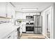 Well-lit kitchen boasts stainless appliances, white cabinetry, subway tile, and elegant countertops at 7804 Bracken Dr, Port Richey, FL 34668