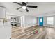 Open-concept living space featuring hardwood floors and a modern kitchen, highlighted by a vibrant blue front door at 7804 Bracken Dr, Port Richey, FL 34668