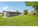 Expansive backyard featuring a screen-enclosed patio and lush green lawn perfect for outdoor activities and entertaining at 7930 Jeffery Ave, North Port, FL 34287