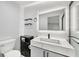 Bathroom with illuminated mirror, modern vanity and dark gray shelving at 7930 Jeffery Ave, North Port, FL 34287