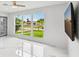 Sunlit living room featuring a large window with neighborhood views and sleek, glossy marble floors at 7930 Jeffery Ave, North Port, FL 34287