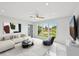 Bright living room with large windows, modern furniture, and sleek tile flooring creating an open, airy space at 7930 Jeffery Ave, North Port, FL 34287