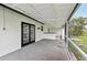 Screened in patio with gray concrete floor, white walls and black door frames, ideal for outdoor relaxation and entertaining at 7930 Jeffery Ave, North Port, FL 34287