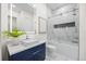 Sleek bathroom featuring a modern vanity, stylish mirror, and a glass-enclosed shower/tub at 820 Bay Point Dr, Madeira Beach, FL 33708