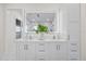 Bright bathroom with a double sink vanity, illuminated mirror, and glass shower at 820 Bay Point Dr, Madeira Beach, FL 33708