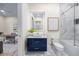 Bathroom with sleek vanity, modern mirror and bathtub featuring an elegant glass enclosure at 820 Bay Point Dr, Madeira Beach, FL 33708